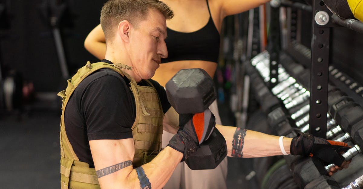Grabbing someone's wrist before they strike....? - Side View of a Man in a Weighted Vest Holding a Dumbbell