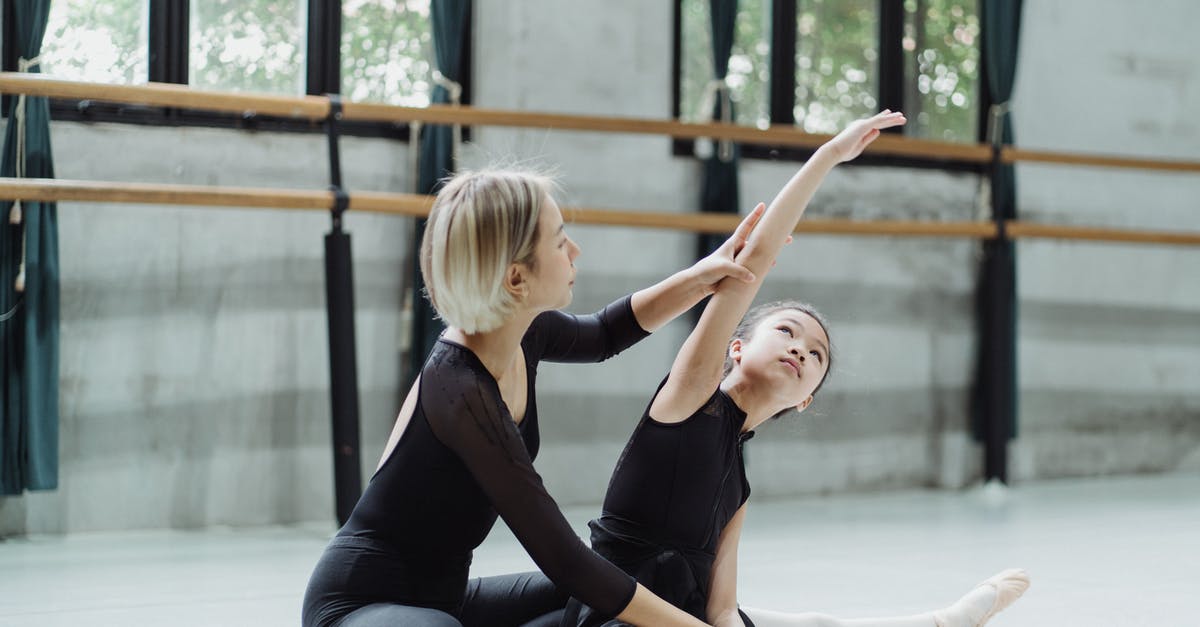 Has any girl trainer won the league in Pokémon? [closed] - Young ethnic female ballet dancer helping pupil to stretch with raised arm while practicing in dancing hall