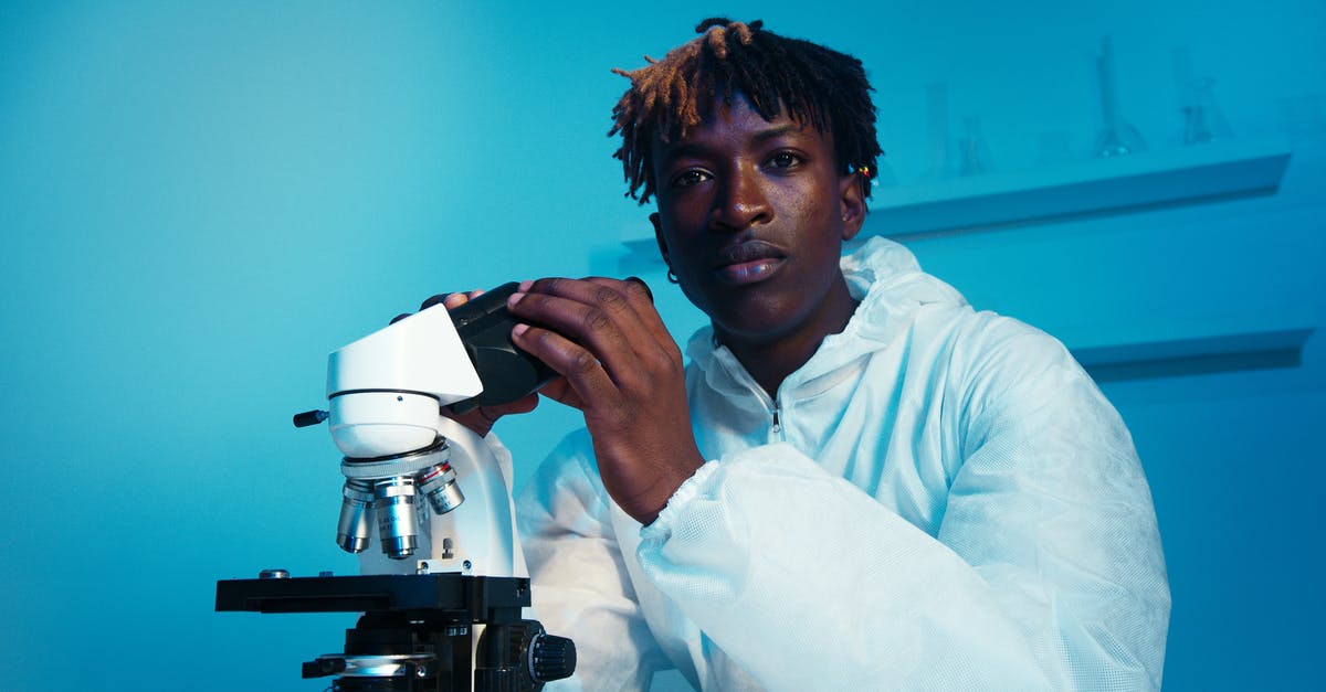 Has Federation medical science really allowed for males to carry a child? - A Man Looking at the Camera While Holding the Eyepiece of the Microscope