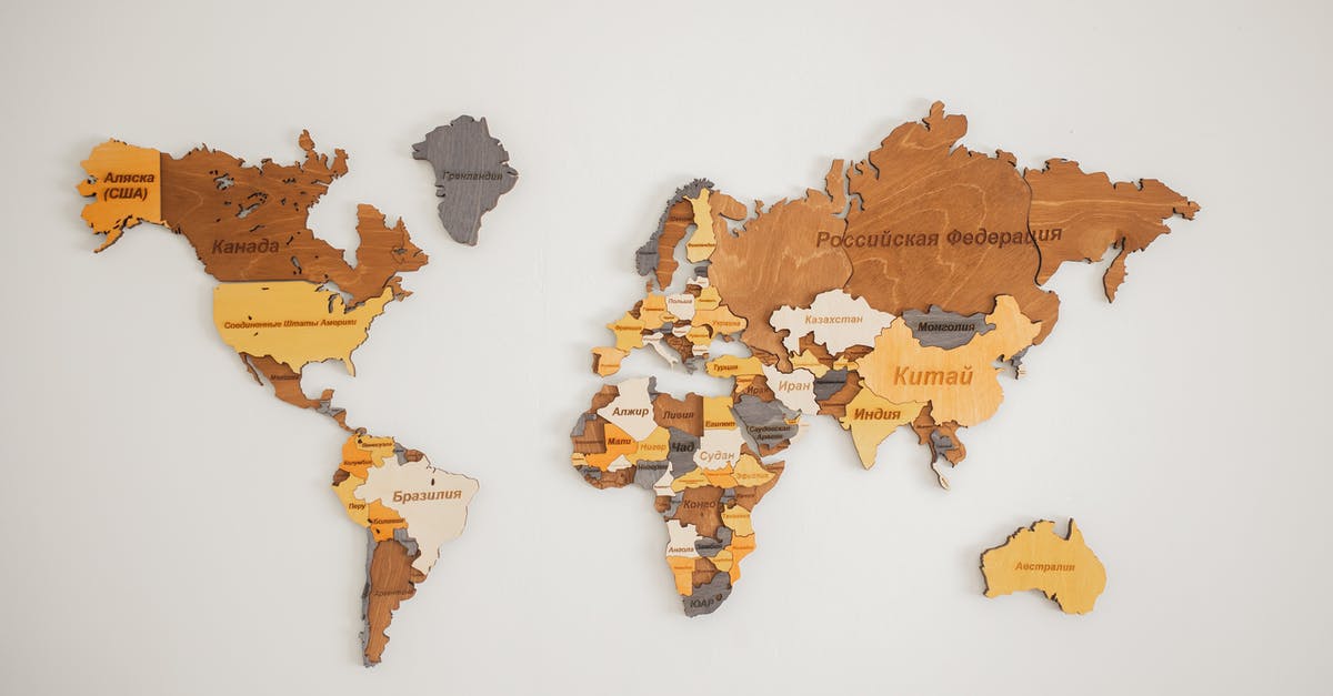 Has the name "White Portuguese" a deeper meaning? - Decorative creative wooden world continents with country names written in Cyrillic attached on white background in light room of studio