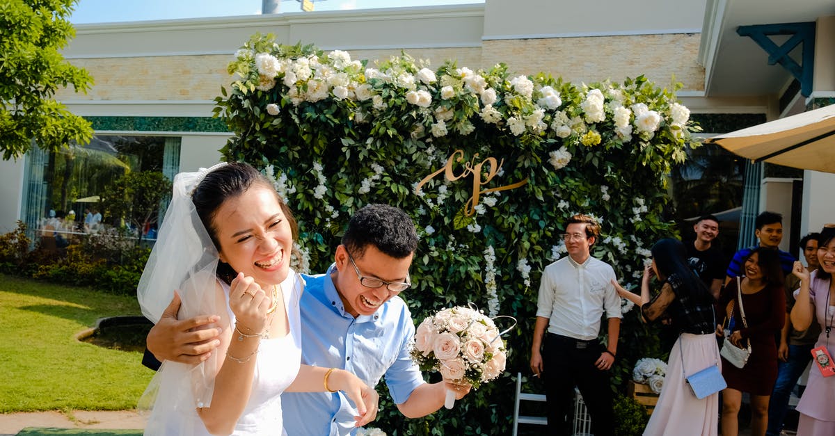 Have any celebrity guests noticeably "aged" over the course of their appearances on The Simpsons? - Side view of happy ethnic groom embracing stylish bride with closed eyes while laughing near flower decor and guests on wedding day in summer