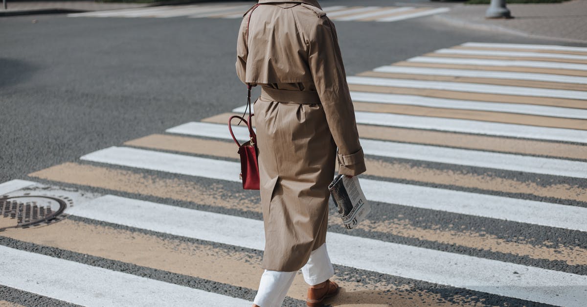 Hebrew newspaper in Laurel & Hardy's Blotto? - Woman in Brown Coat and White Pants Walking on Pedestrian Lane
