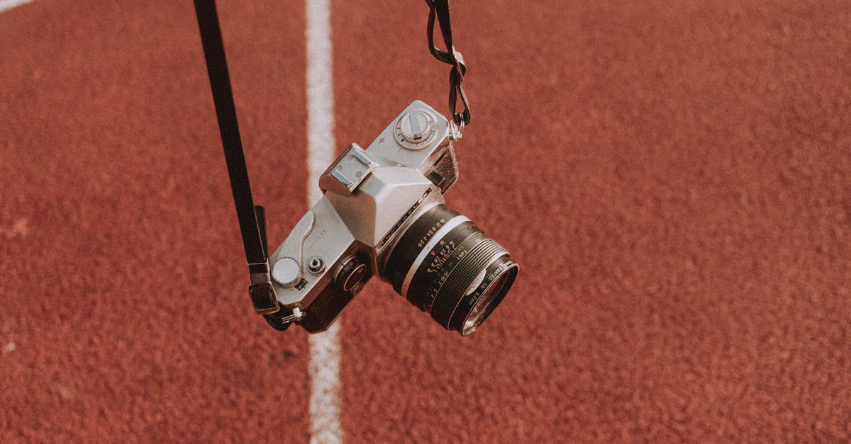 History and reasoning behind average length of a feature film - Aged photo camera fixed on thin leather belts above textured sports ground in daylight