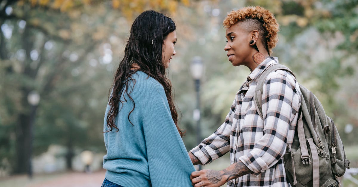 Hitman falls in love, woman likely not target, maybe met in blind date [closed] - Smiling black lesbian woman pulling girlfriend close in park