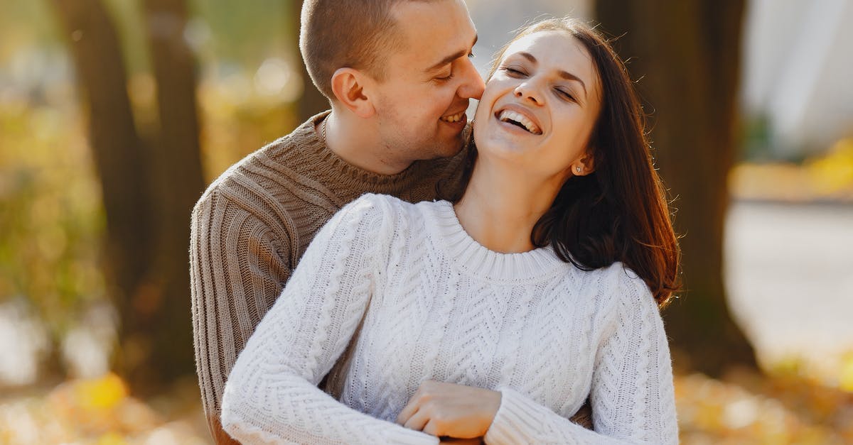 Hitman falls in love, woman likely not target, maybe met in blind date [closed] - Tender adult man and laughing young woman hugging with closed eyes while standing close to each other during romantic date in park