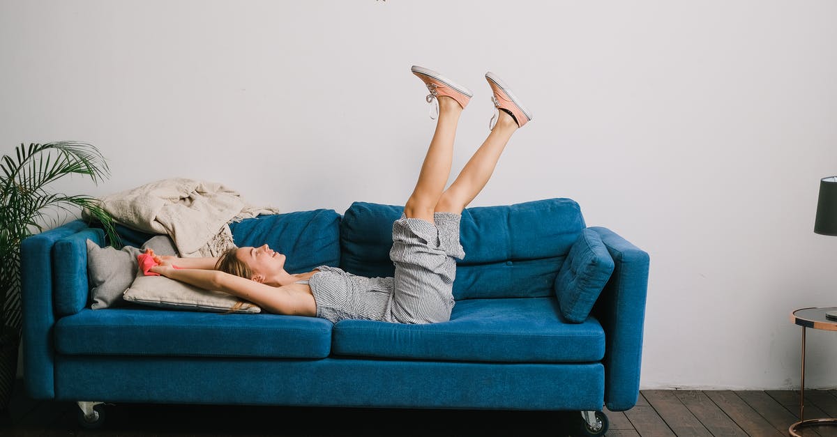 House of Lies freeze frame effect - how is it done? - Side view of cheerful young woman with rag and raised legs lying on sofa after housework
