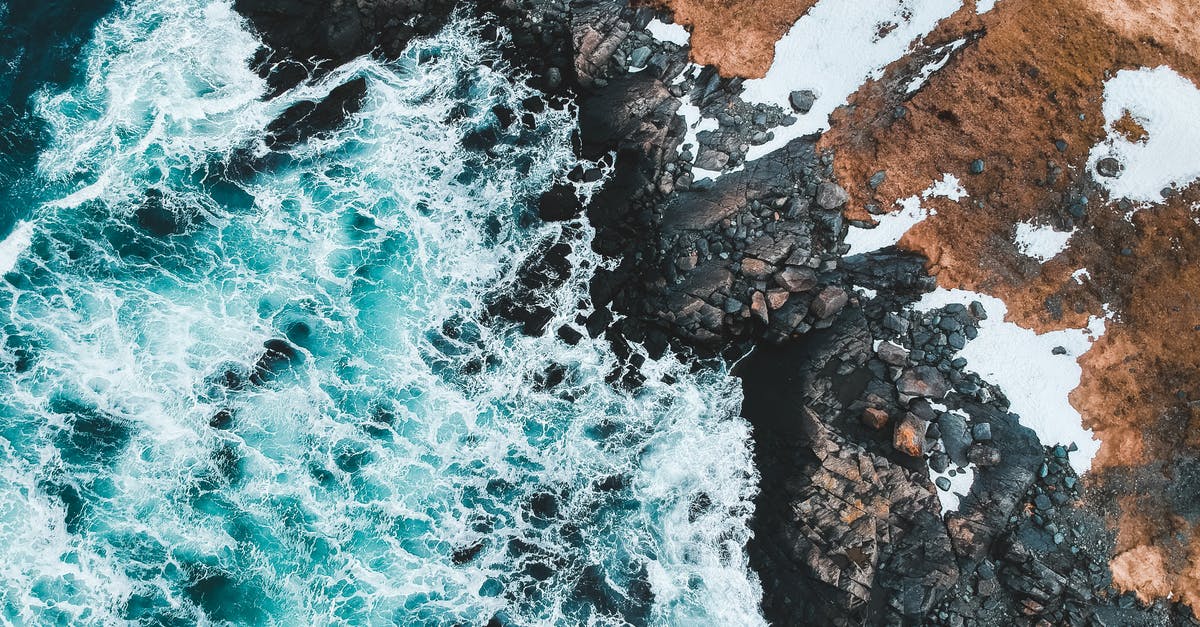 How are all the chief's stones on the one island in Moana? - Aerial View of Ocean Waves Crashing on Rocky Shore