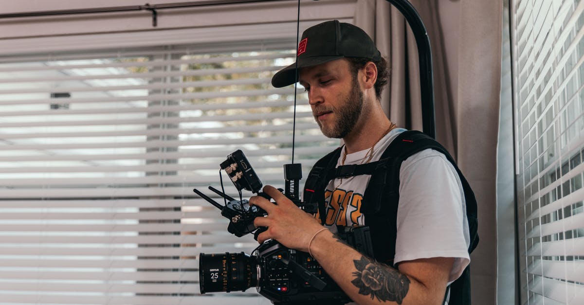 How are scenes shot in burning buildings? - A Man Wearing Camera Harness Holding a Camera
