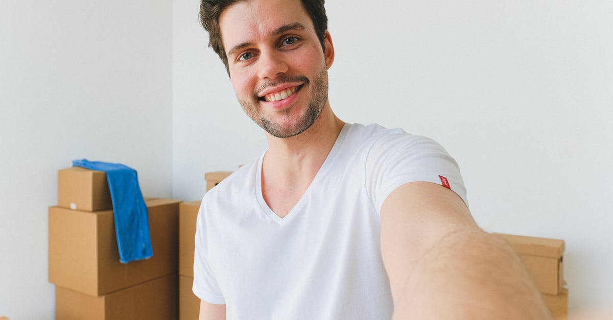 How are the measurements used by Nielsen evolving to meet new methods of content delivery and viewing? - Positive young woman and focused man carrying cardboard boxes in new apartment on moving day