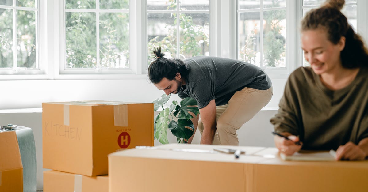 How are the measurements used by Nielsen evolving to meet new methods of content delivery and viewing? - Delighted young relocating man with dark hair in white t shirt smiling and looking at camera while taking selfie against pile of cardboard boxes in new purchased apartment