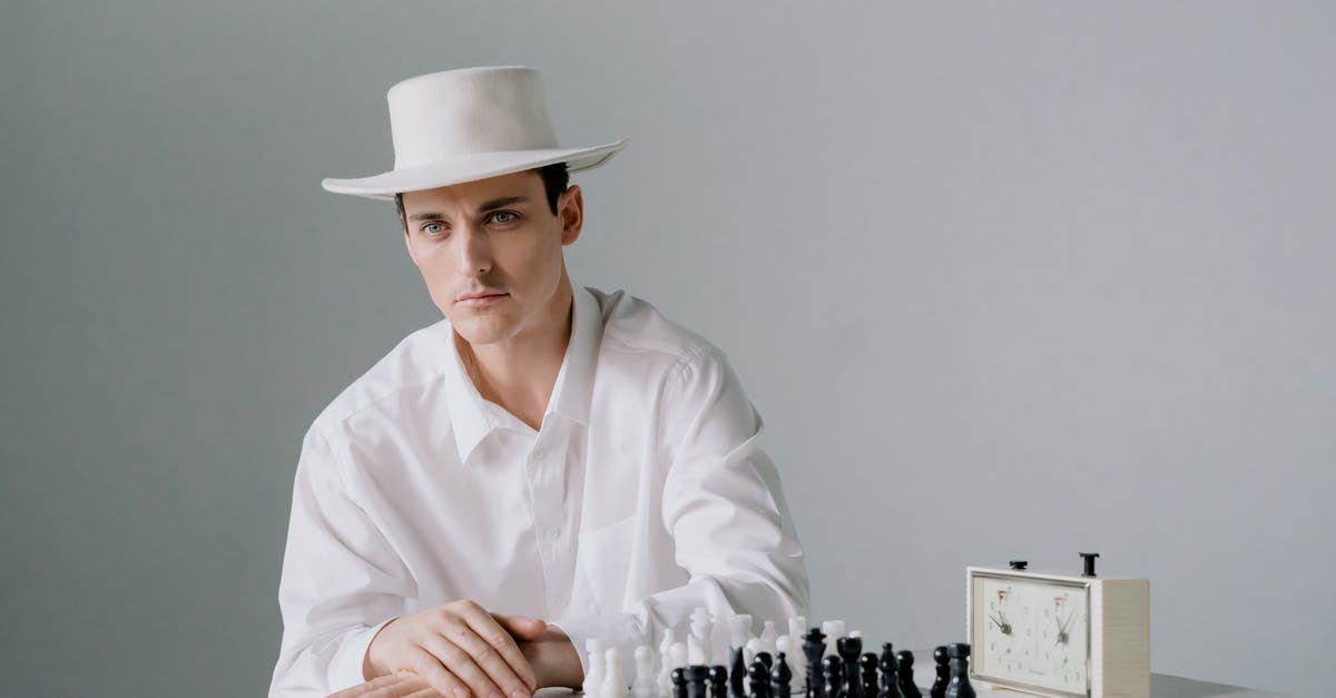 How can a chess game with clock take 5 hours? - Man in White Clothing Sitting in Front of a Chessboard