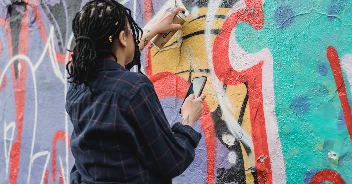 How can Daniel Hardman come back, against Pearson's wishes, 5 years after resigning? - Back view of unrecognizable female artist with black braided hair painting graffiti on wall with spray paint can on street