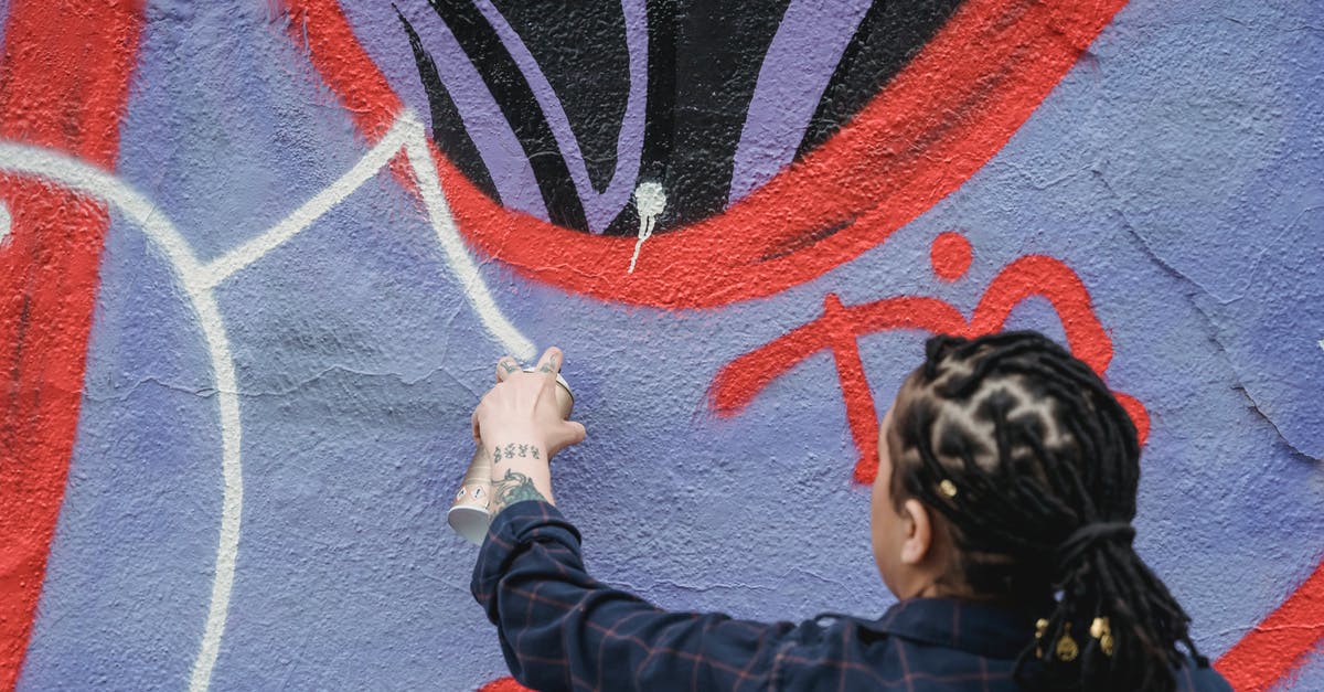 How can Daniel Hardman come back, against Pearson's wishes, 5 years after resigning? - Back view of unrecognizable female artist with black braided hair spraying white paint on colorful wall while standing on street