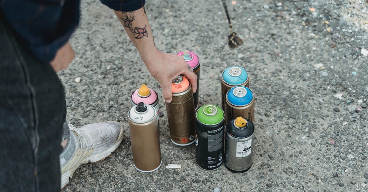 How can you tell distances/duration in Paths of the soul? - Crop faceless tattooed artist taking paint bottle from heap of multicolored spray cans placed on ground on street of city