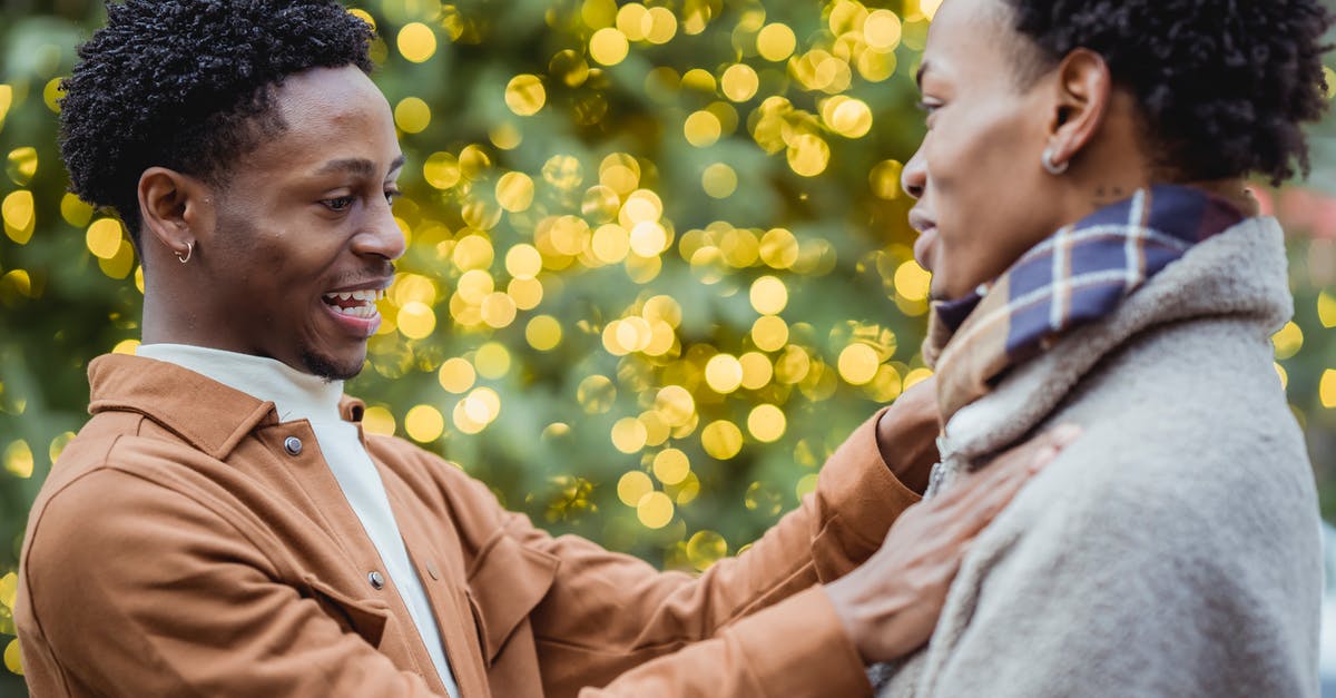 How close is Masters of Sex to the actual events? - Side view of cheerful enamored African American guy in stylish clothes adjusting scarf of happy boyfriend near Christmas tree with glowing garlands