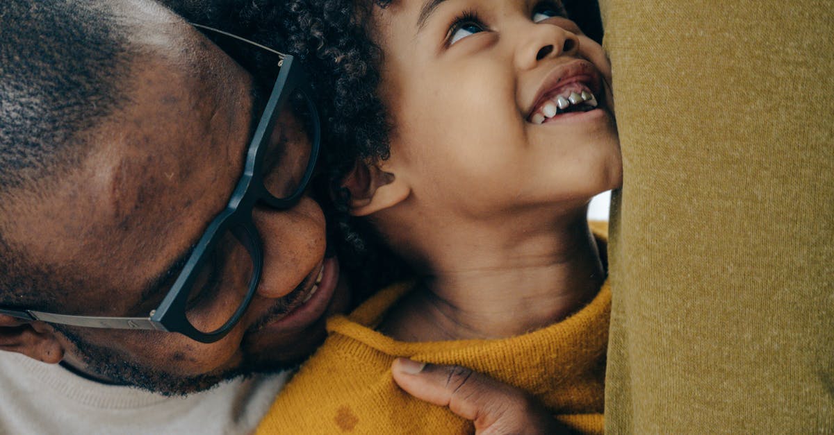 How could any of the children of Noah and Allie have kids with black hair? - Crop cheerful African American man in casual shirt and eyeglasses hugging cute smiling son with curly hair in daytime