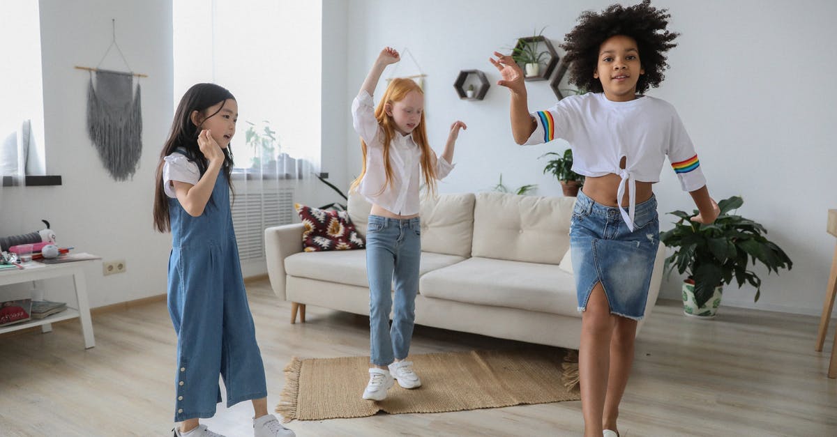 How could Kazan's testimony to the House Committee on Un-American Activities affect him negatively? - Content multiracial children dancing with raised arms on floor near sofa in living room