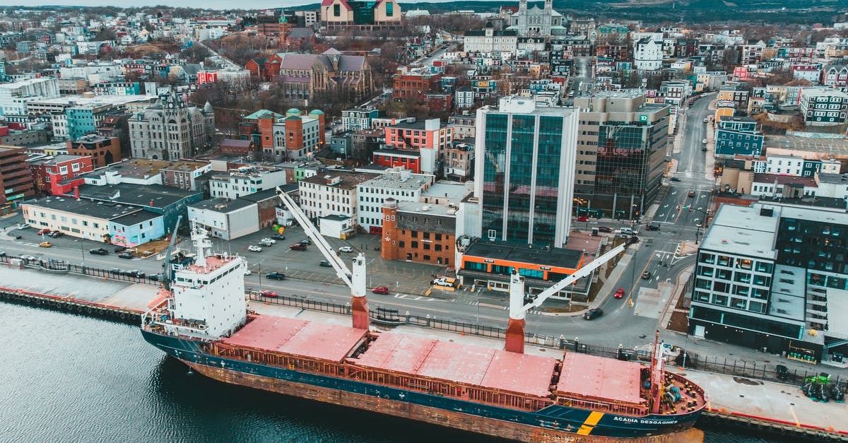 How detrimental was the initial hull breach by the shipping container for the boat's ultimate fate? - Ship moored in seaport with modern buildings
