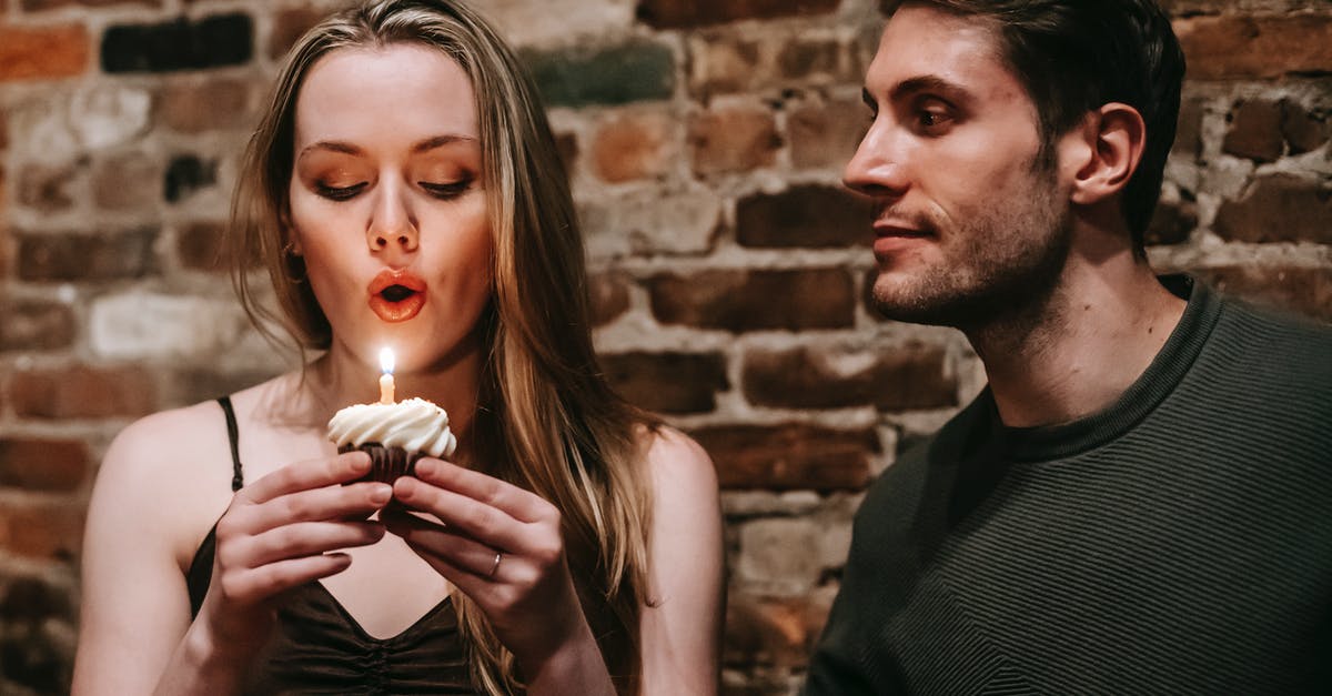 How did Andy make the tunnel with such a small hammer? - Young couple in elegant outfits in restaurant while blowing in candle on small cupcake and celebrating birthday near brick wall