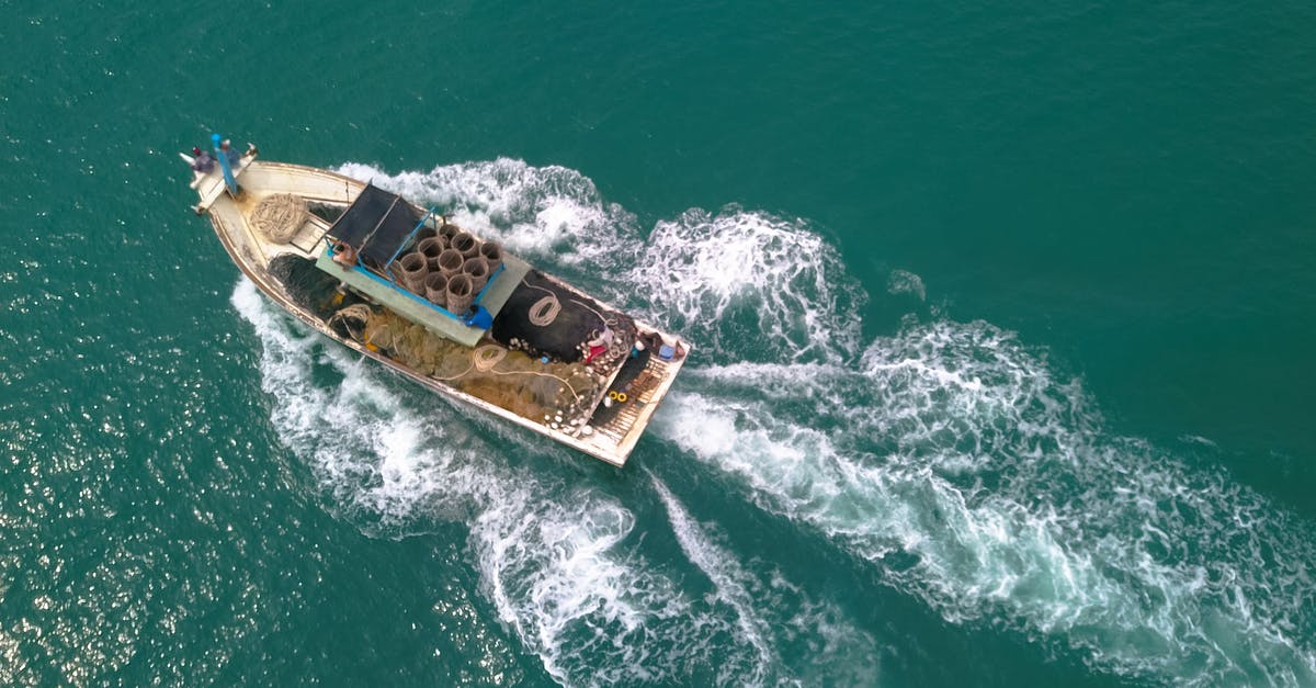 How did Arkangel still work after Sara became a teenager? - Drone view of boat with open deck and fishing equipment floating on calm sea at daytime