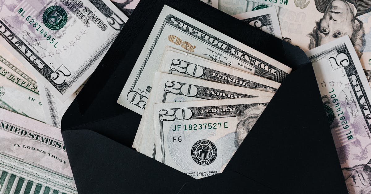 How did Bill Denbrough know that at the end? - From above of dollar bills in opened black envelope placed on stack of United states cash money as concept of personal income