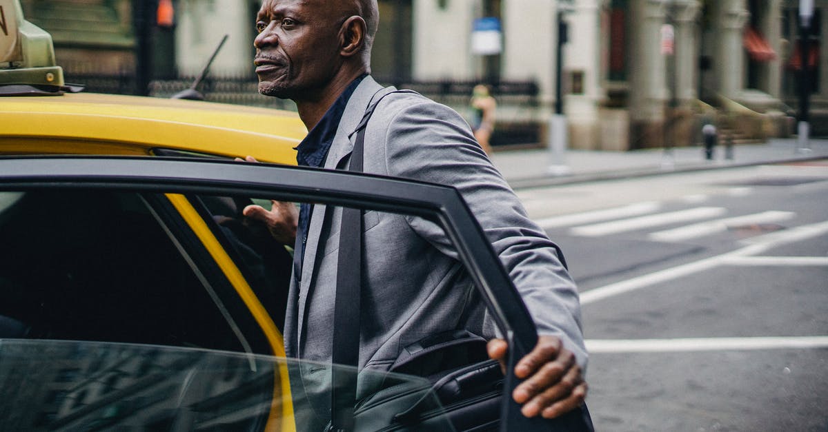 How did Butch manage to open the cab door with his boxing gloves on? - Mature contemplative African American male office worker with briefcase standing on city roadway near cab transport while looking away