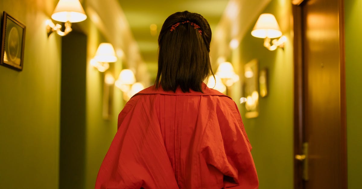 How did Chigurh find the hotel he was staying at? - Woman in Red Dress Standing in the Hallway