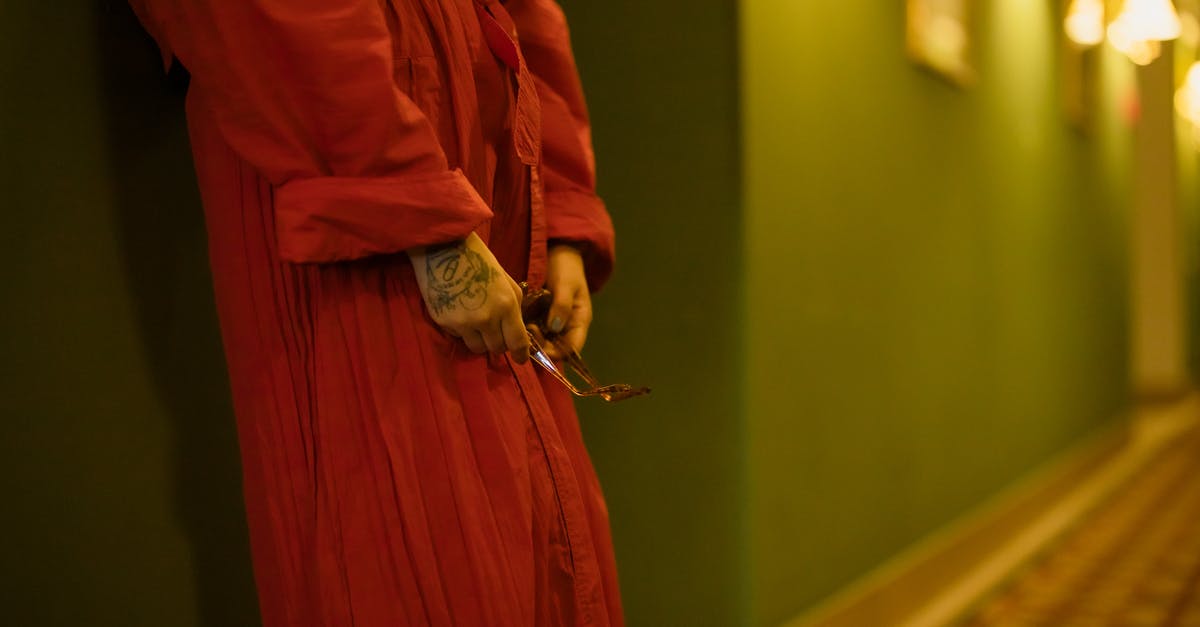 How did Chigurh find the hotel he was staying at? - Woman in Red Dress Leaning on the Wall