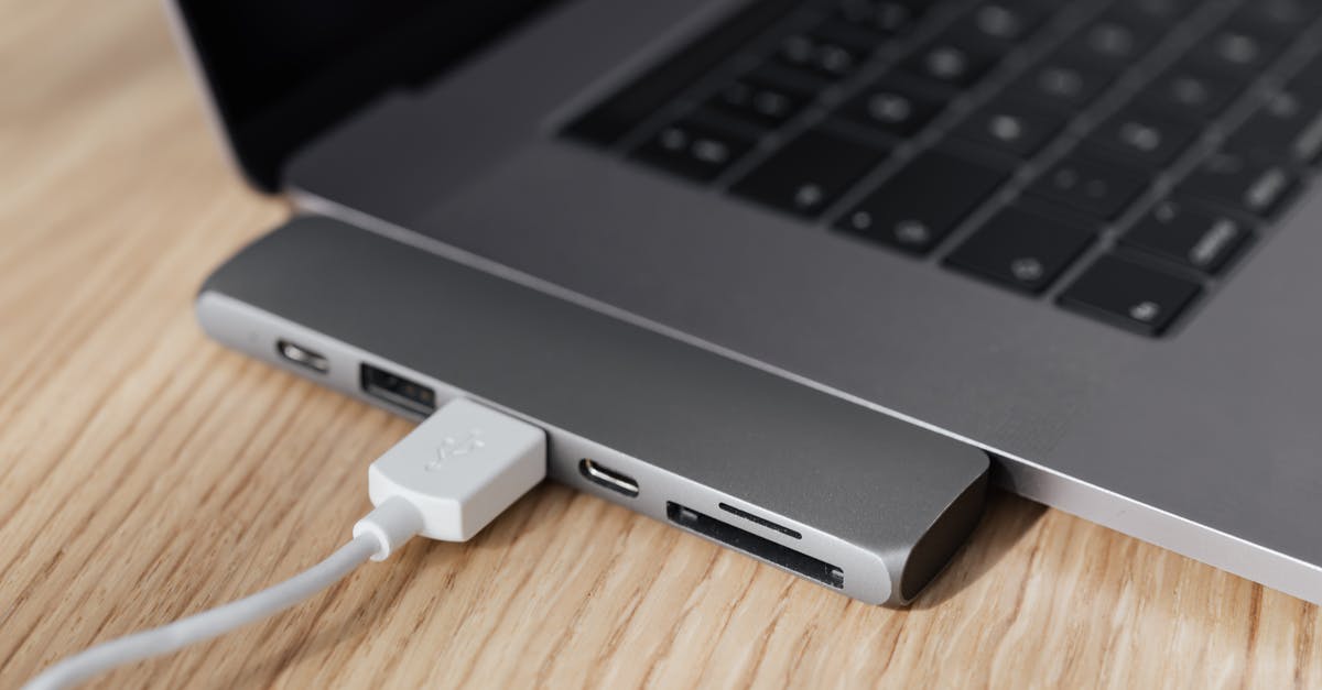 How did Hub and Garth know what happened? - High angle of modern space silver laptop with USB type c multiport hub with plugged white cable placed on wooden table
