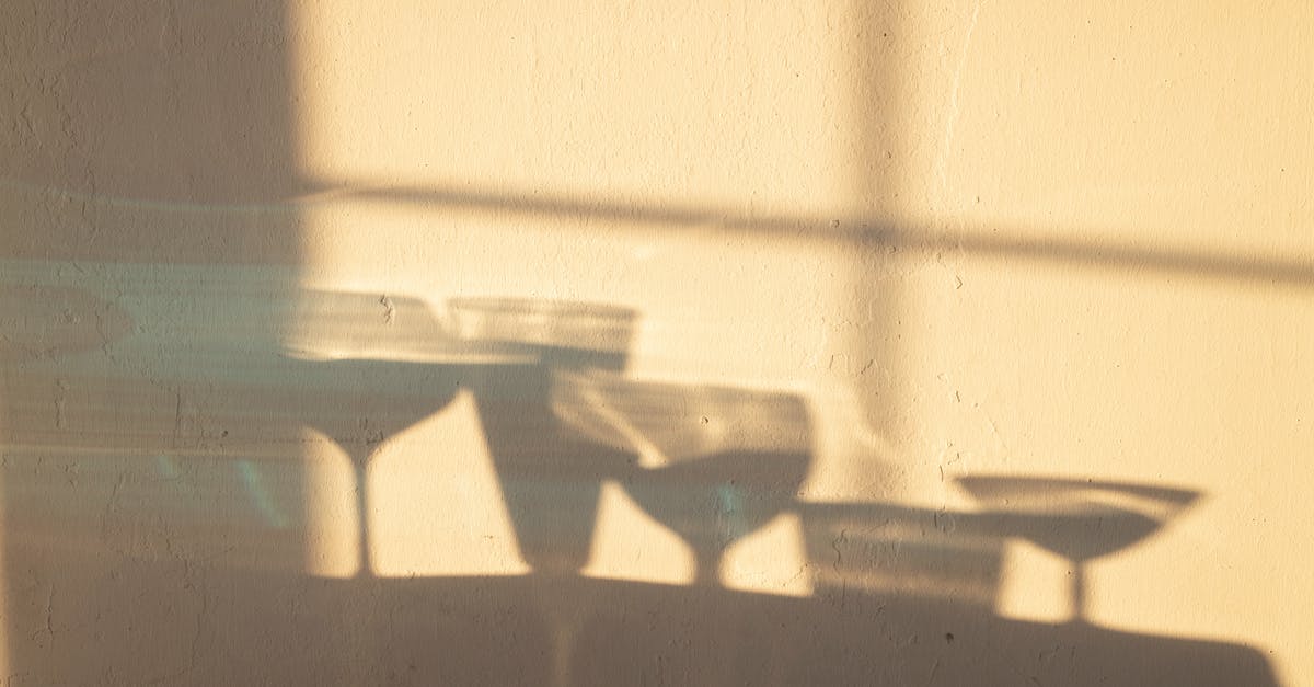 How did John Wick get stabbed with a champagne glass in chapter one? - Shadows of different crystal glasses filled with drinks reflecting on white wall in sunlight
