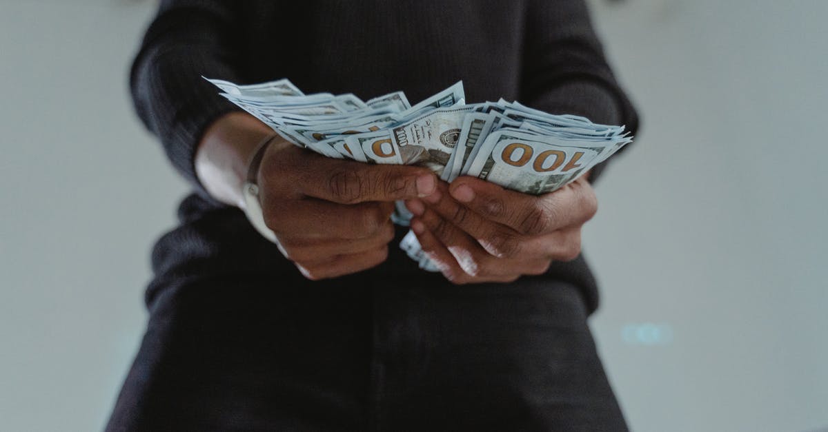 How did Ocean's Thirteen made their profit [closed] - Close-Up Photo of a Person's Hands Holding Dollar Bank Notes