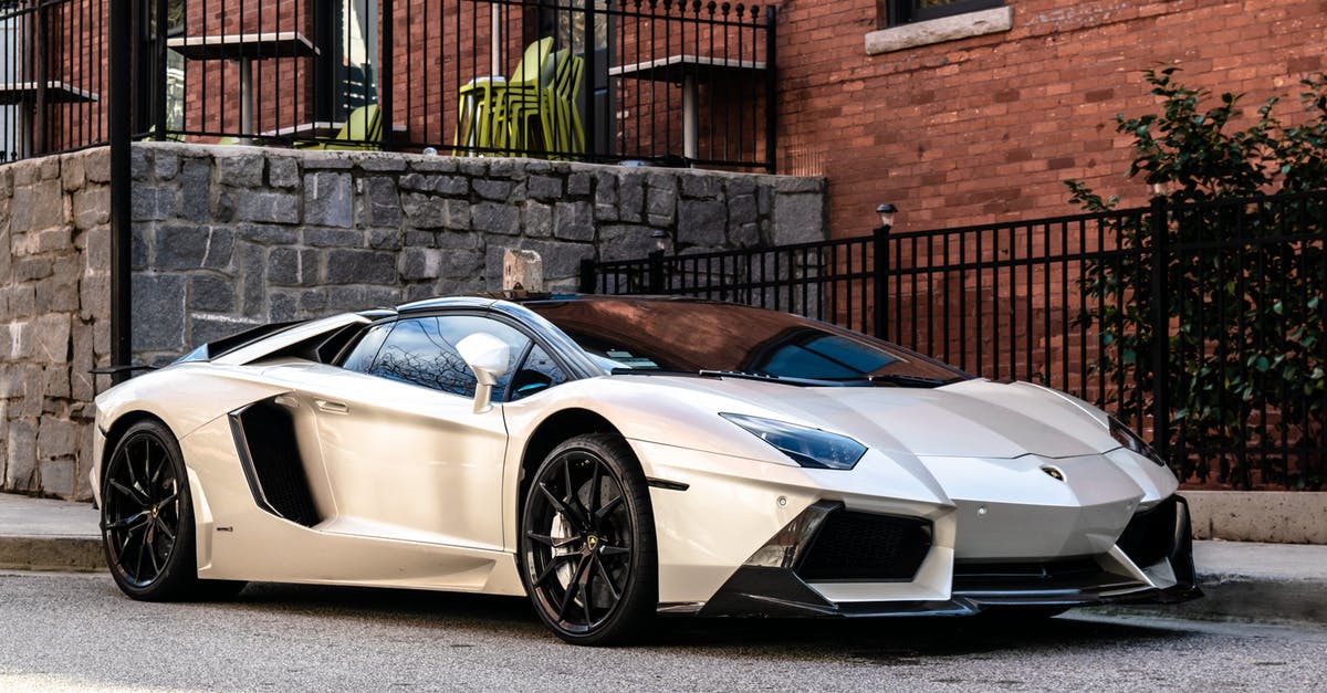 How did Pirates of the Carribbean: On Stranger Tides become the most expensive movie ever made? - White and Blue Lamborghini Aventador Parked Beside Brown Brick Wall