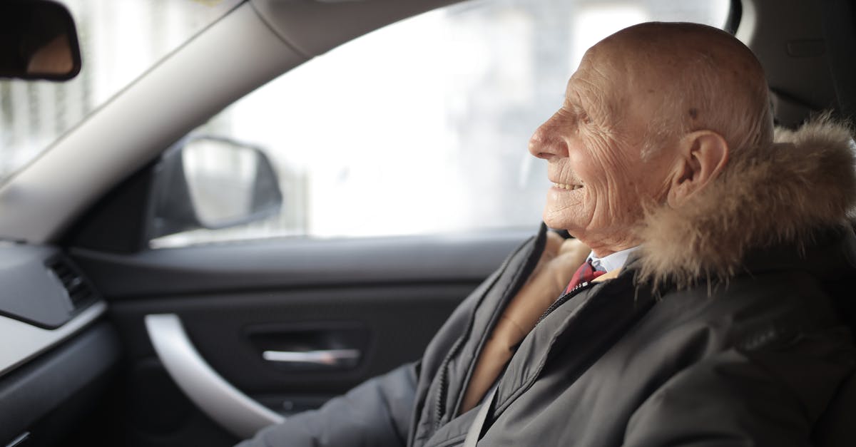 How did the emergency vehicles get there so quickly? - Side view of content elderly male in suit and outerwear sitting in front seat of contemporary automobile and looking away