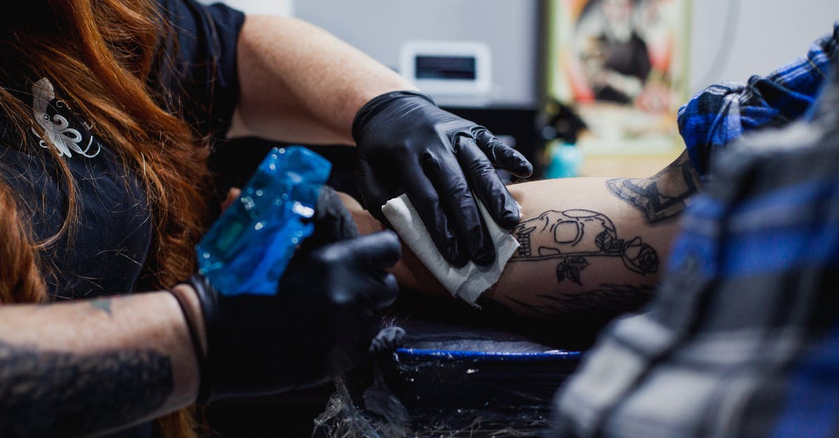 How did the machine work in the alternate timeline? - Faceless woman in black gloves doing tattoo with gun on arm of man in salon