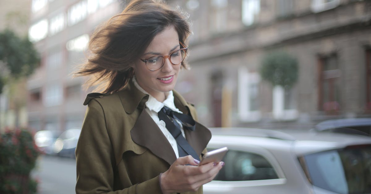 How did the woman fly through the wind screen? - Stylish adult female using smartphone on street