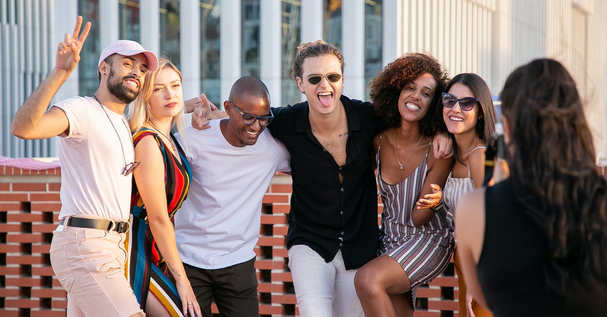 How did they shoot this tongue pulling scene? - Faceless lady taking photo of positive diverse millennials during open air party