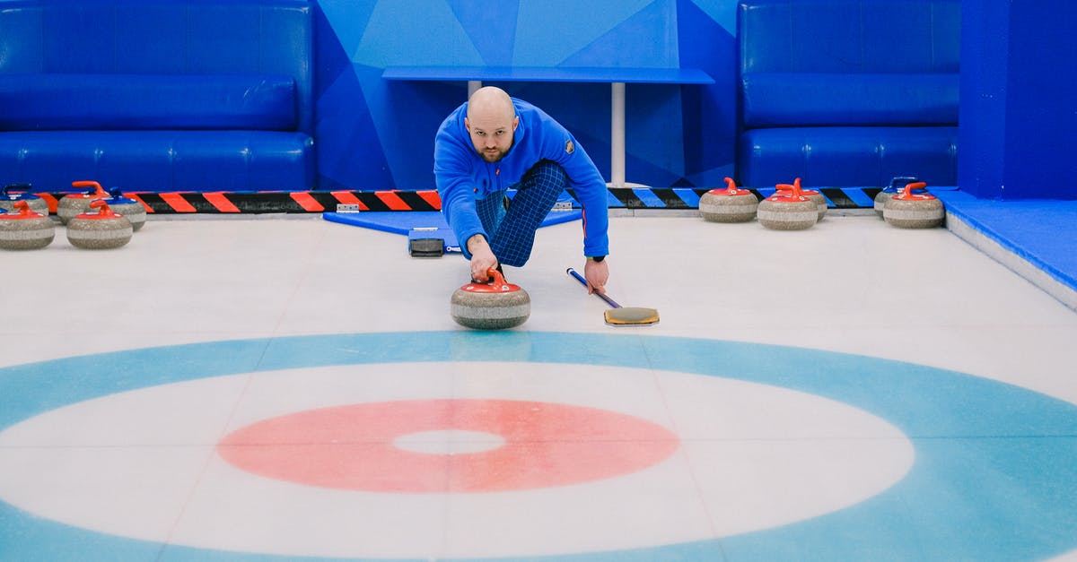 How did Thor know the Power stone was in play? - Focused male in blue activewear choosing tactic and throwing stone while playing curling on ice rink
