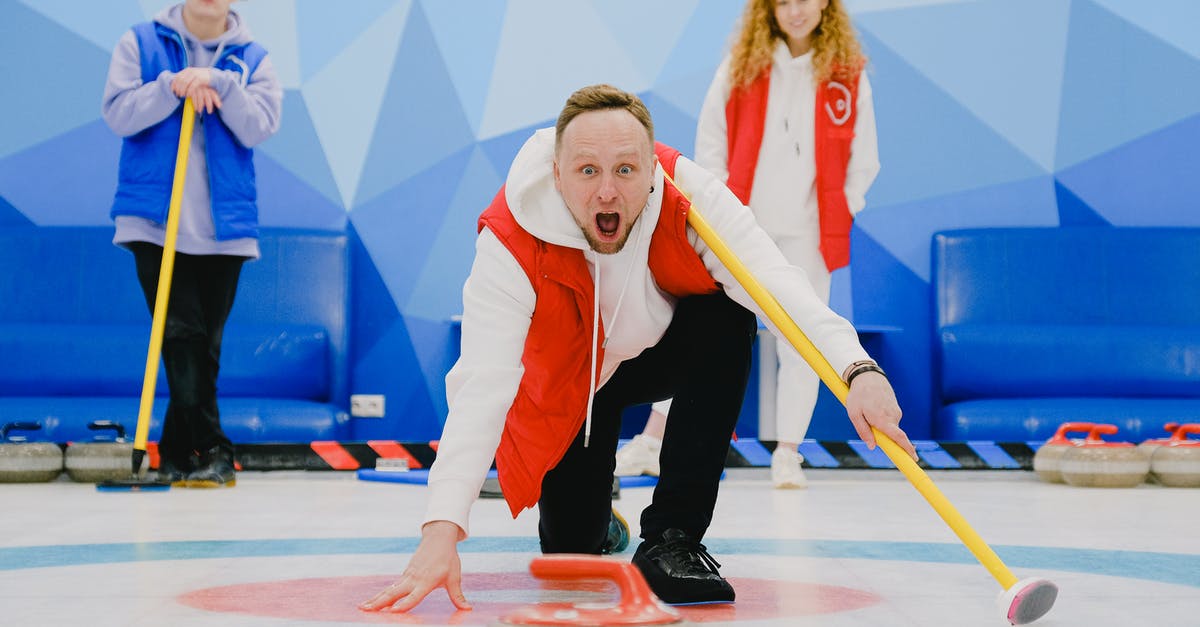 How did Thor know the Power stone was in play? - Excited sportsman with open mouth in activewear standing on knee with broom and throwing stone with red handle while playing curling on ice rink
