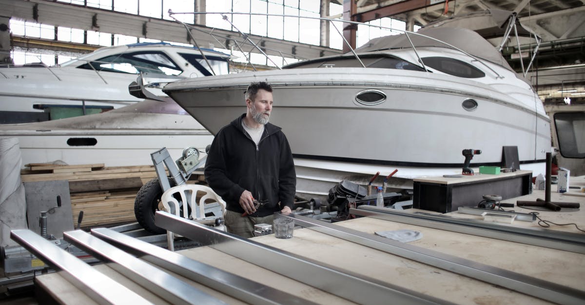 How did Tony fix himself by the end of Iron Man 3? - Focused adult worker preparing metal details in workshop with yachts