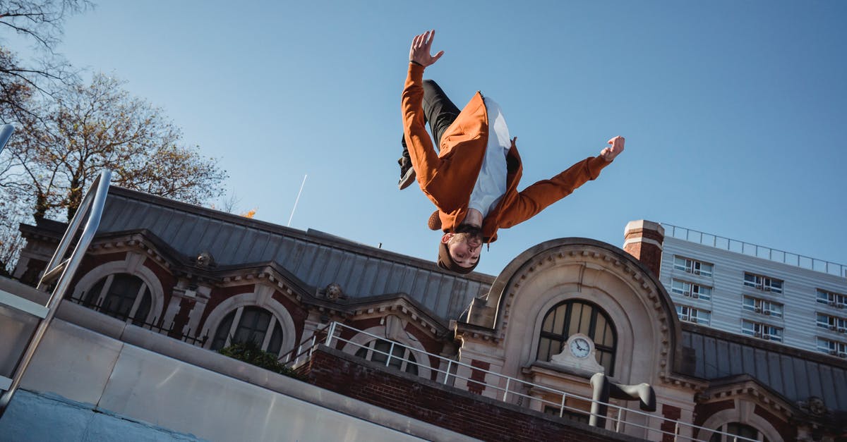 How did Virginia jump from bullet trains when it slowed down? [closed] - From below of sportsman jumping in air while demonstrating upside down trick during training against urban building