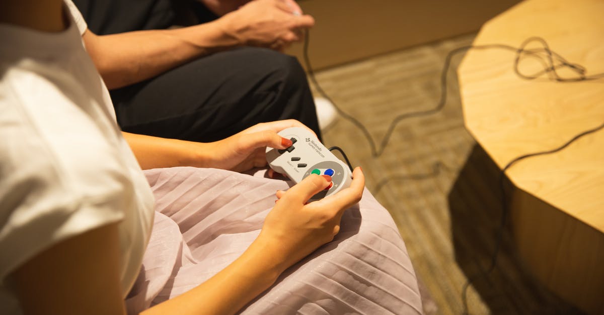 How do the characters' timelines interact in The Witcher TV series? - Unrecognizable couple playing video game with gamepads at home