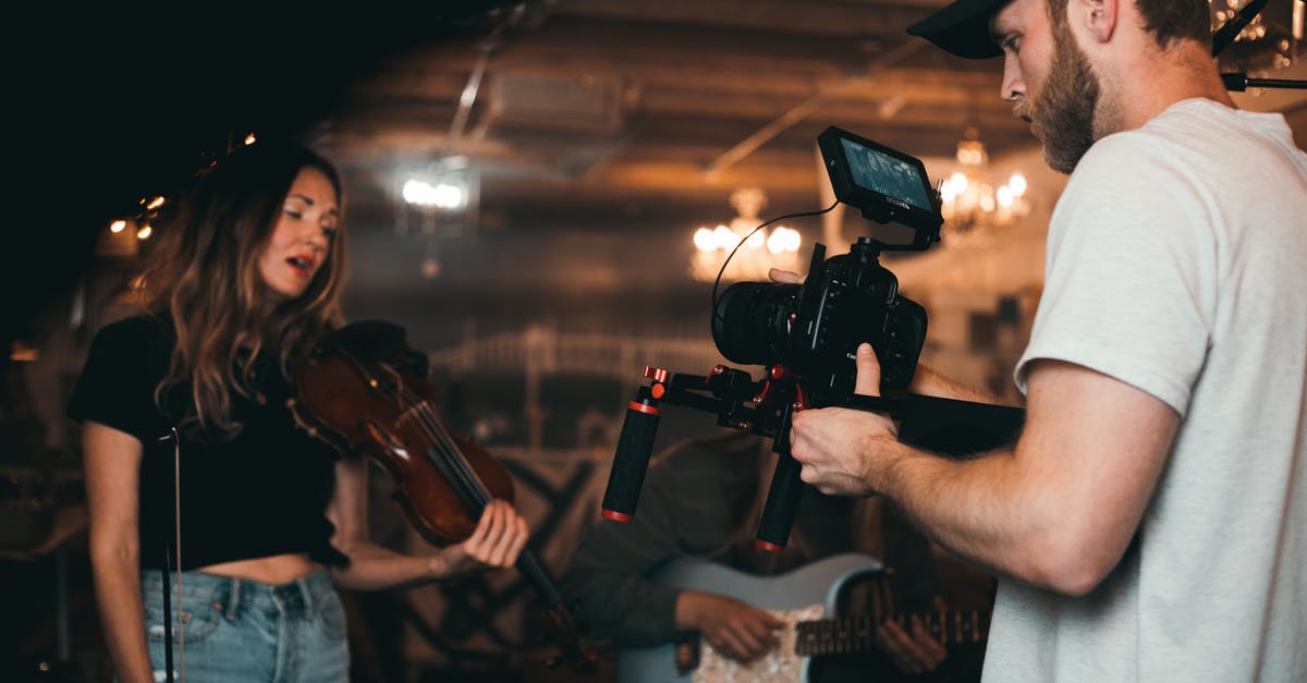 How do they film "flying human" scenes? - Man Taking a Video of a Woman Carrying a Violin