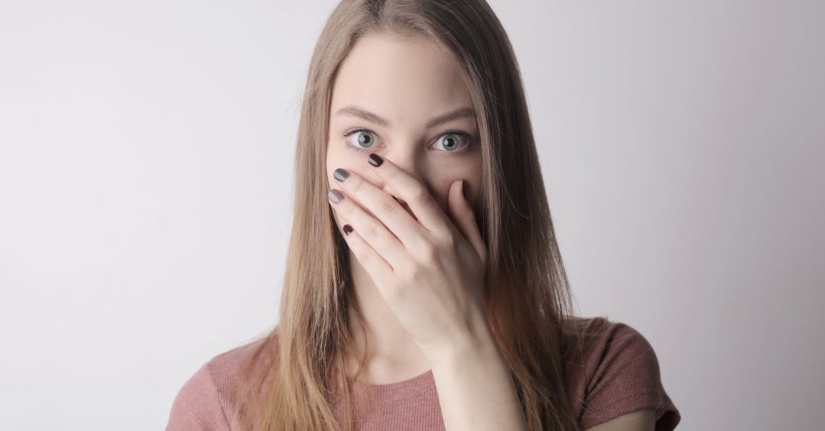 How do they keep the identity of the winner secret? - Young amazed woman in casual wear covering mouth while keeping secret