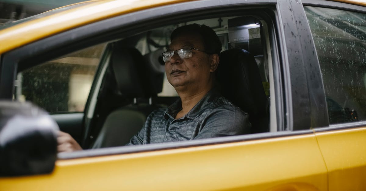 How do they move puppets inside the car? - Serious ethnic man driving yellow cab on city street