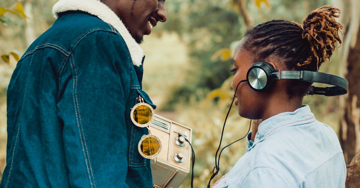 How does Baby listen to Doc's plan if he has his headphones on? - Woman Wearing Headphones Standing Beside Man