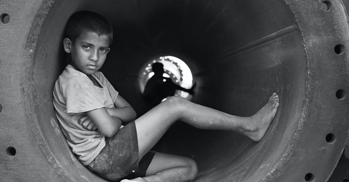 How does Christopher Moltisanti respond to the "bridge and tunnel boy" insult? - Grayscale Photo of Boy in Crew Neck T-Shirt Sitting in Round Pipe