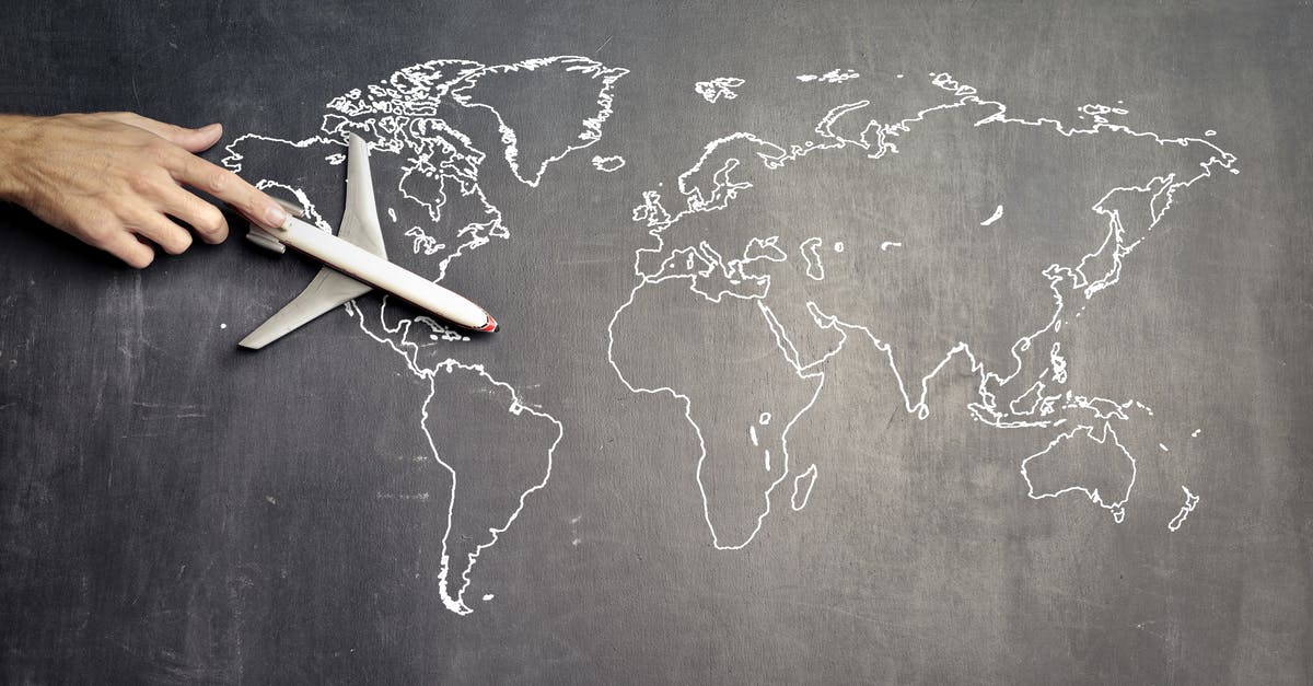 How does Cole get from the First World War to 1996? - From above of crop anonymous person driving toy airplane on empty world map drawn on blackboard representing travel concept