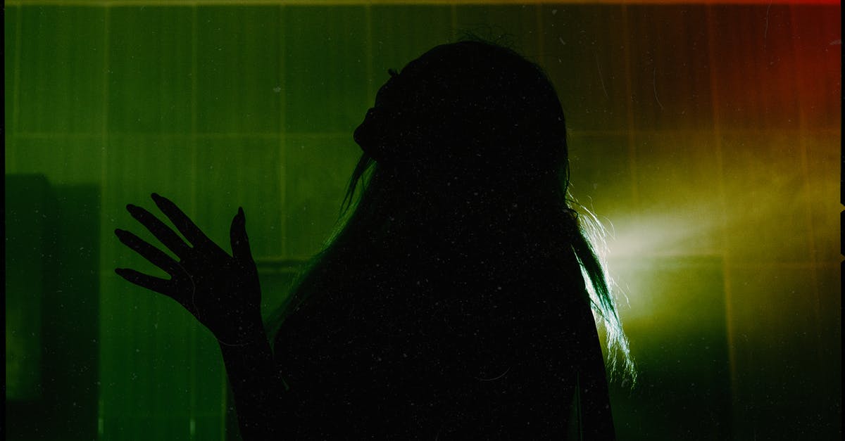 How does Groot spread light? - Side view silhouette of female throwing head back and raising hand with spread fingers while standing in dark room against dim green light