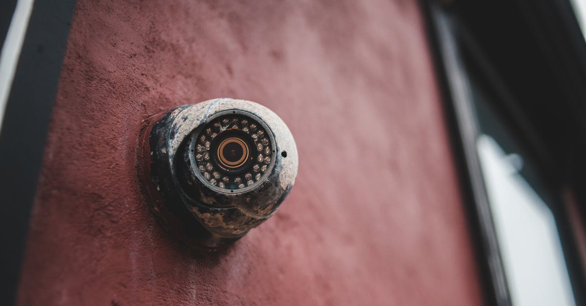 How does video come on the walls of the buildings? - Old security camera on shabby building wall