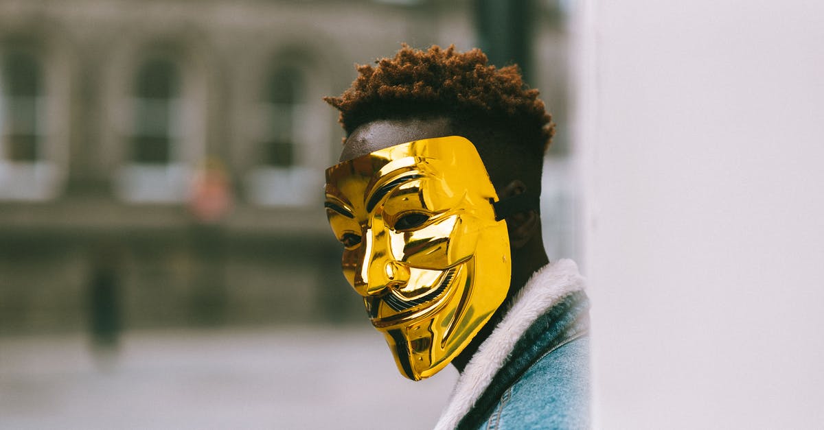 How exactly did Chihiro guess it right in Spirited Away? - Black activist in golden Anonymous mask standing on city street
